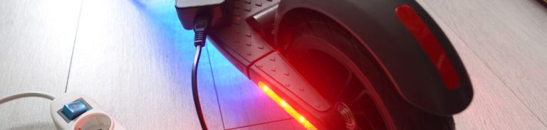 parkirani električni romobil na punjenju baterije