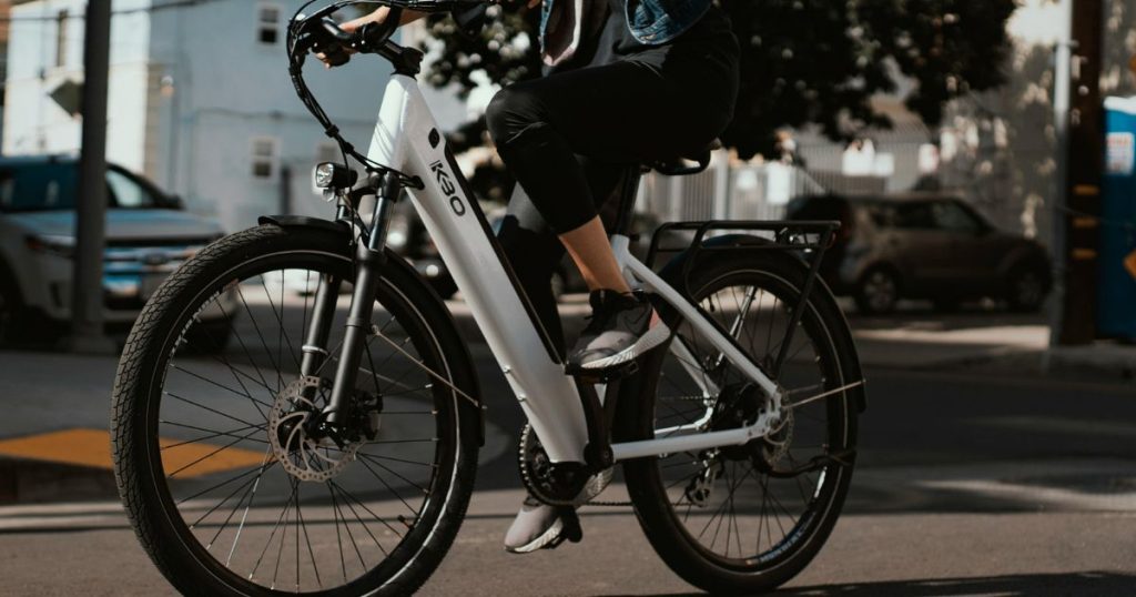 osoba u vožnji gradom na električnom biciklu
