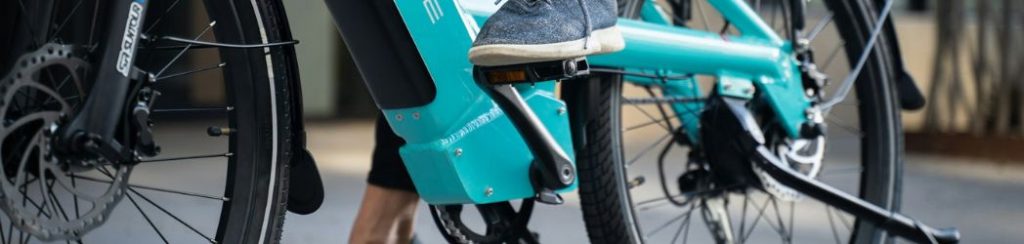 osoba vozi električni bicikl tirkizne boje