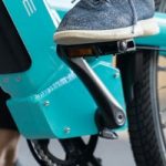 osoba vozi električni bicikl tirkizne boje