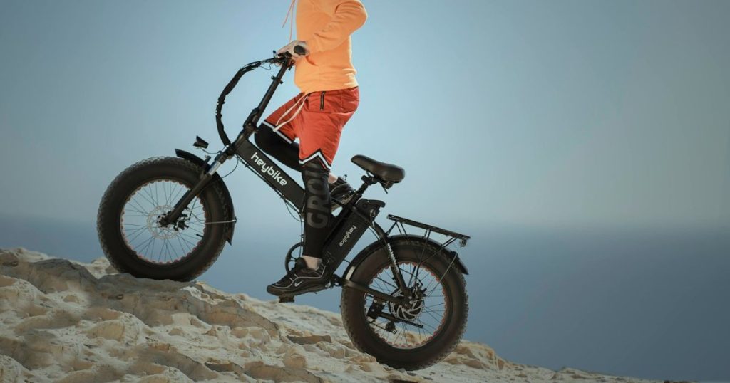 vozač sa terenskim električnim biciklom se vozi uz brdo